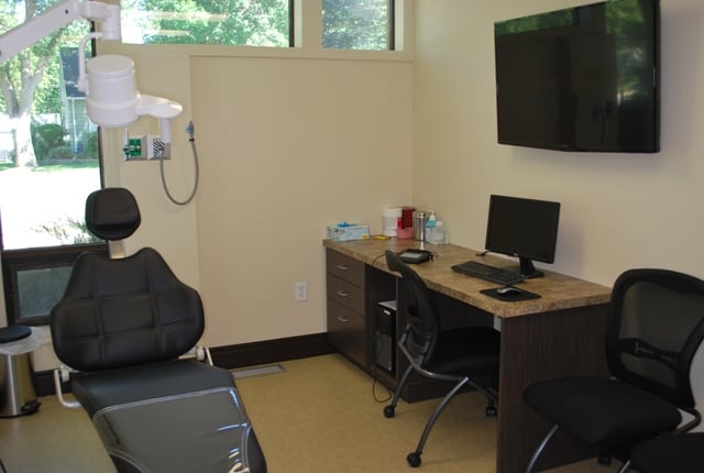 Close-up of a modern dental treatment chair and adjustable medical overhead lighting.