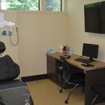 Close-up of a modern dental treatment chair and adjustable medical overhead lighting.