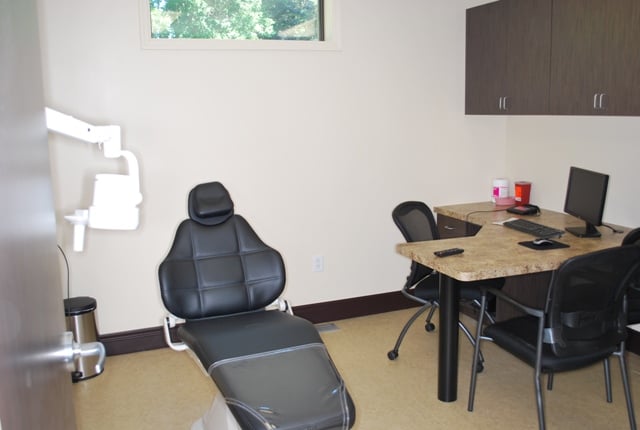 Close-up of a modern dental treatment chair and adjustable medical overhead lighting.