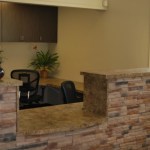 Reception counter featuring a stacked stone facade and brown granite countertop.