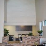 View of an office reception area with high ceilings, track lighting, and a stone-front desk.
