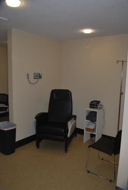 Wide-angle view of a dental treatment suite with large windows and specialized medical cabinetry.