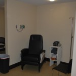 Wide-angle view of a dental treatment suite with large windows and specialized medical cabinetry.