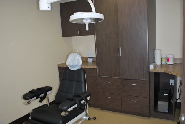 Clinical treatment room featuring a reclining dental chair and integrated medical equipment.