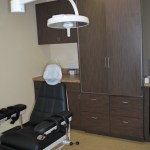 Clinical treatment room featuring a reclining dental chair and integrated medical equipment.