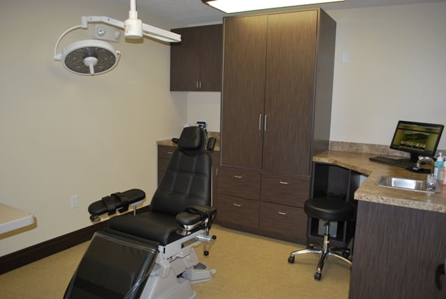 Clinical treatment room featuring a reclining dental chair and integrated medical equipment.