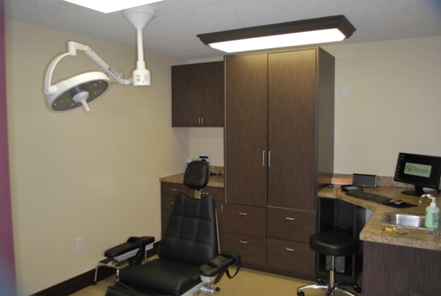 Clinical treatment room featuring a reclining dental chair and integrated medical equipment.